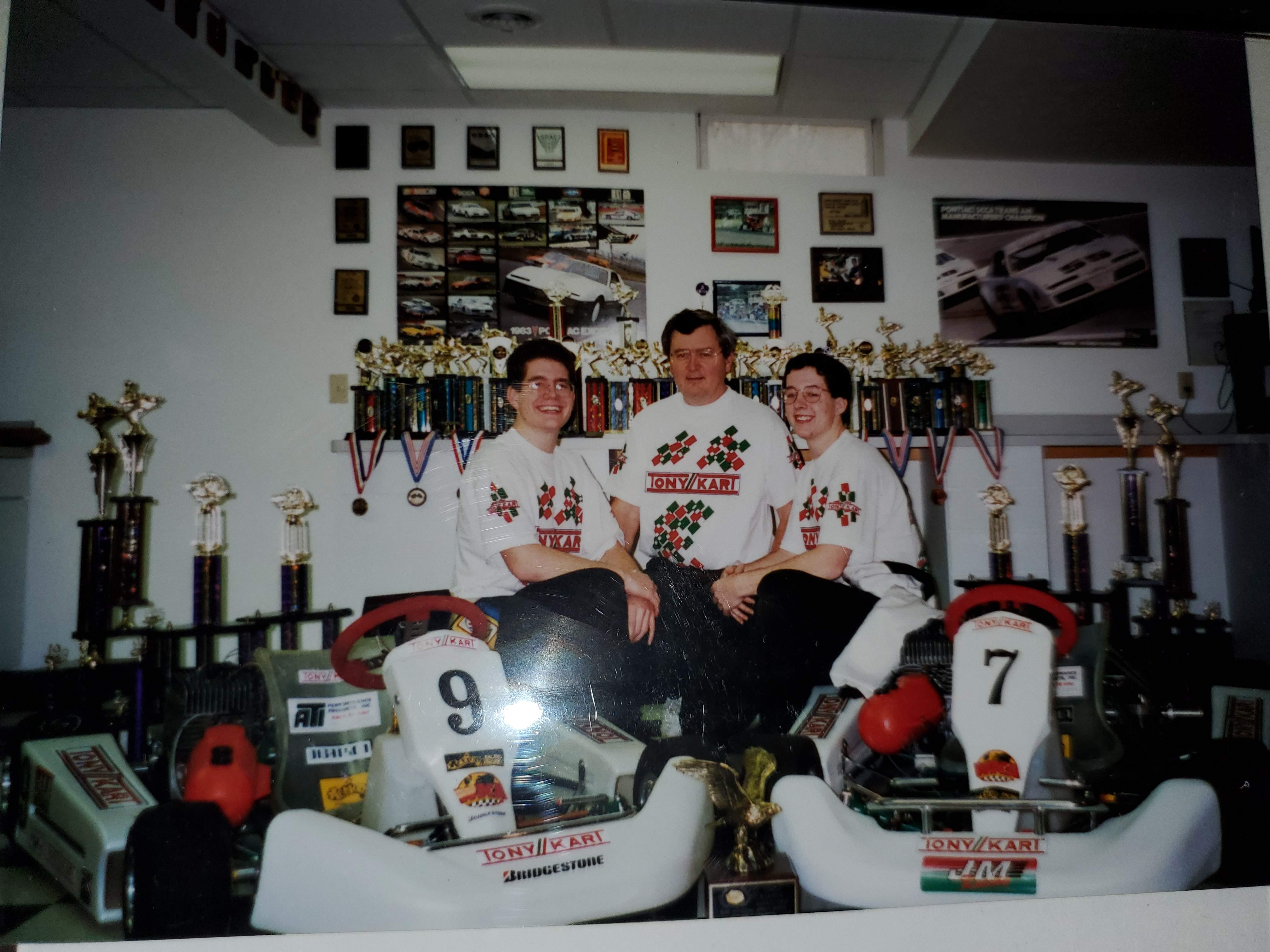 David Galownia with his sons in a garage full of karting trophies