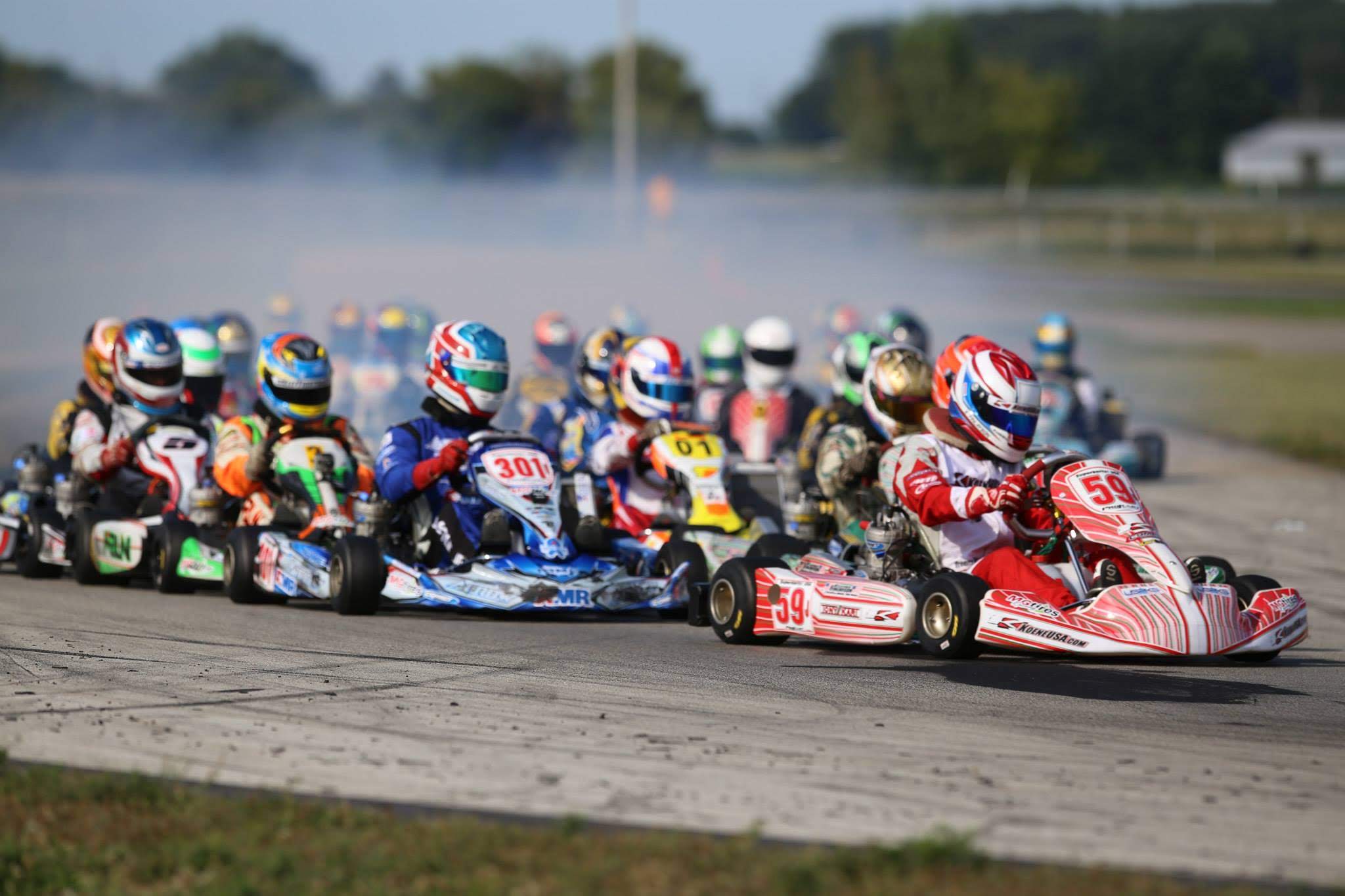 A pack of kart racers fighting into the first corner